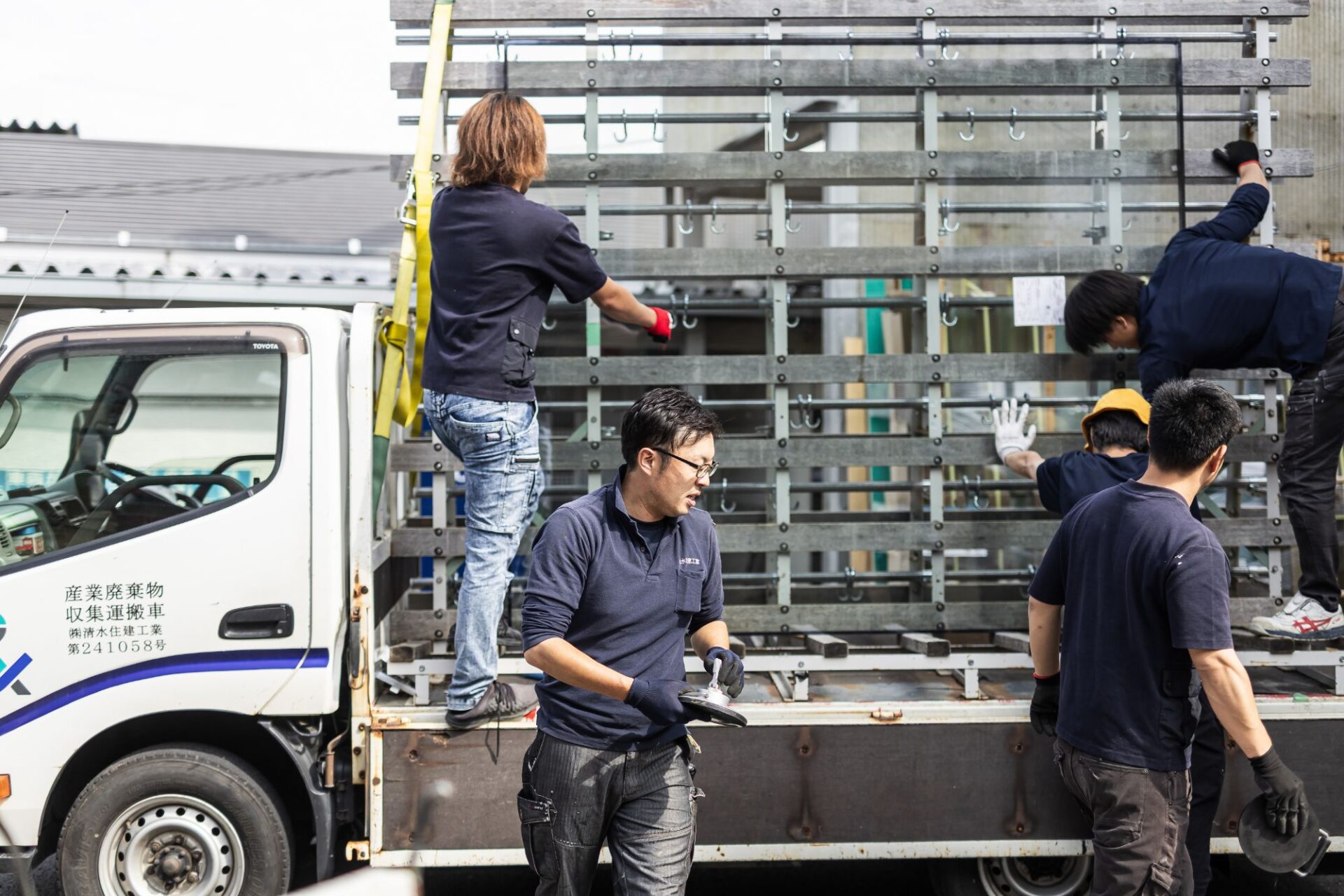 トラックからガラスを降ろす配達・施工スタッフ