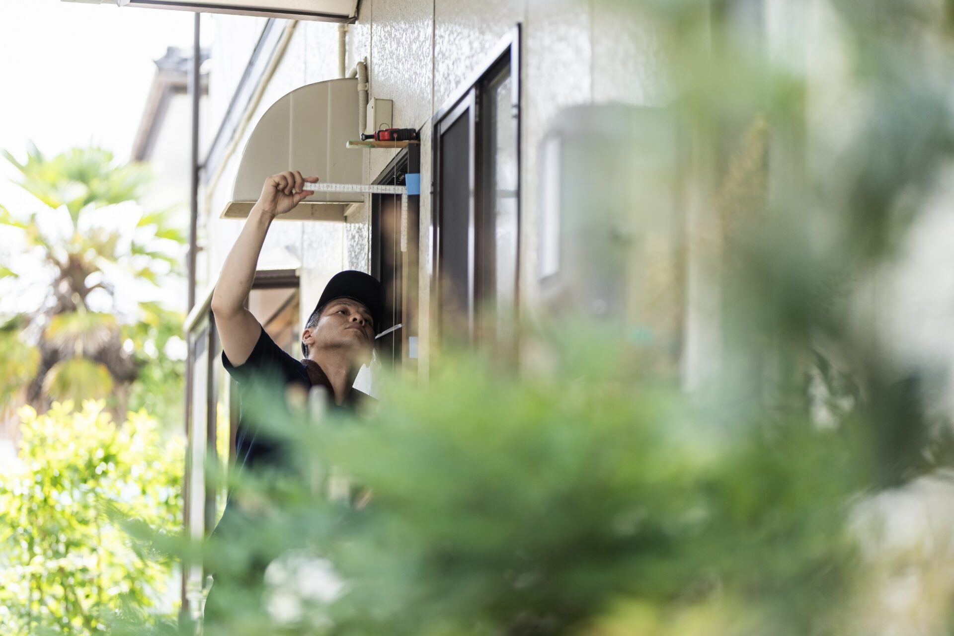 窓の寸法を確認する現場スタッフ